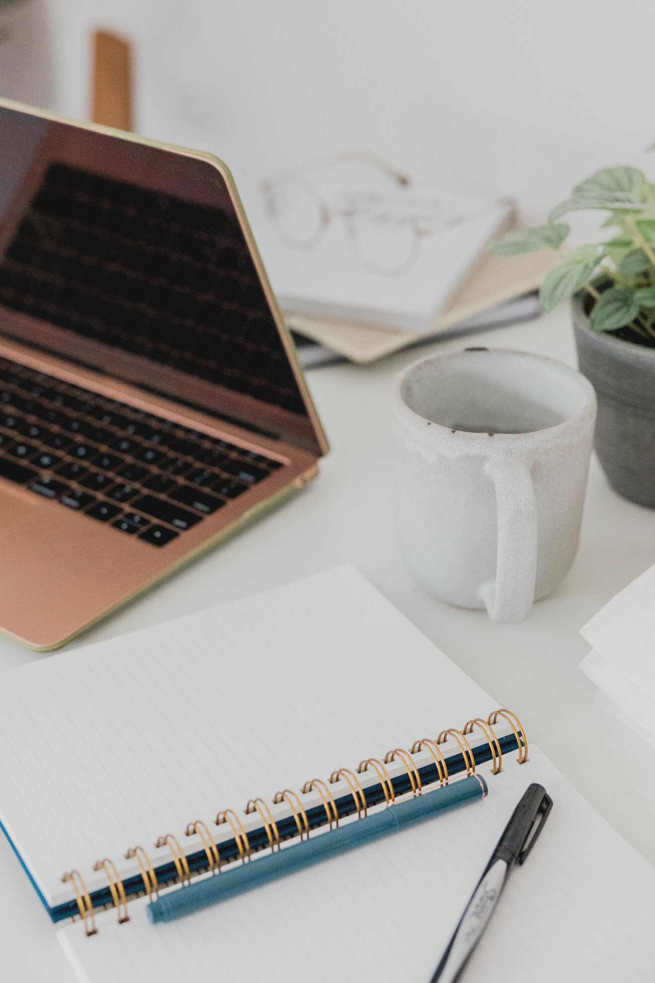 Laptop with Notebook and Cup of Coffee on Table